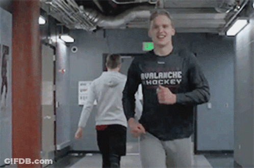 Man In Black Avalanche Hockey Shirt Running In Hallway GIF