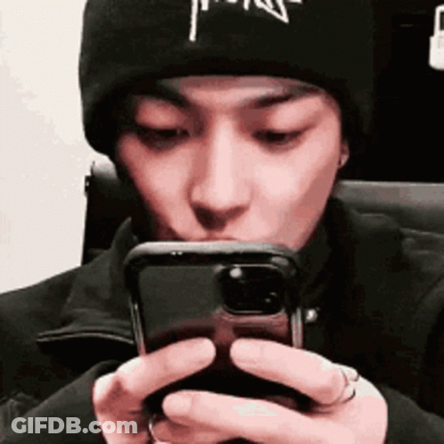 Man In Black Beanie Looking At Phone GIF