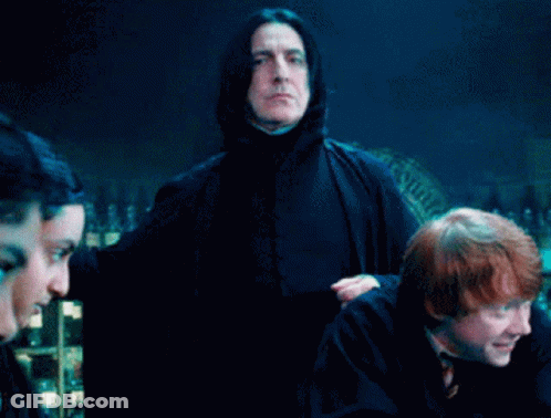 Man In Black Cape Holding Pot In Front Of Group GIF