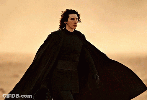 Man In Black Cape Walking Across Desert GIF