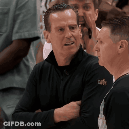 Man In Black Cavs Shirt Talking To Another Man GIF
