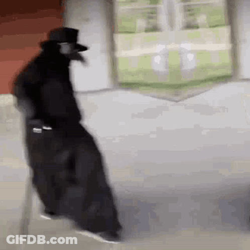 Man In Black Cloak And Top Hat Walking Down Street GIF