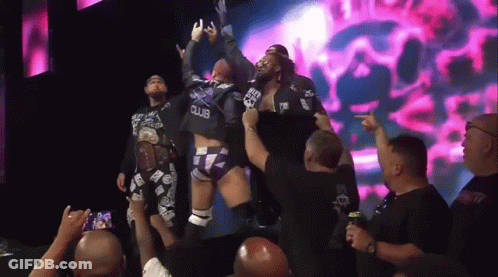 Man In Black Club Shirt Lifted By Another GIF