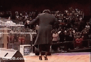 Man In Black Coat And High Heels On Stage GIF