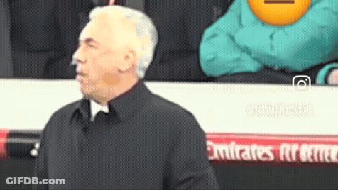 Man In Black Coat Before Emirates Banner GIF