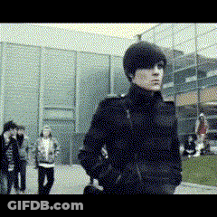 Man In Black Coat In Front Of Building GIF
