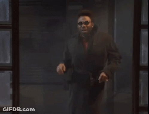 Man In Black Coat Standing By Dark Window GIF