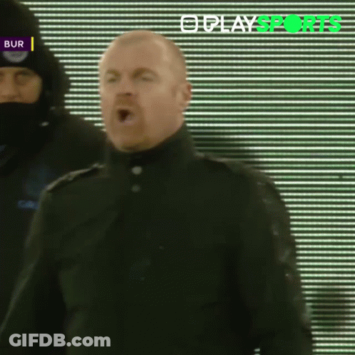 Man In Black Coat Standing In Front Of Play Sports Screen GIF