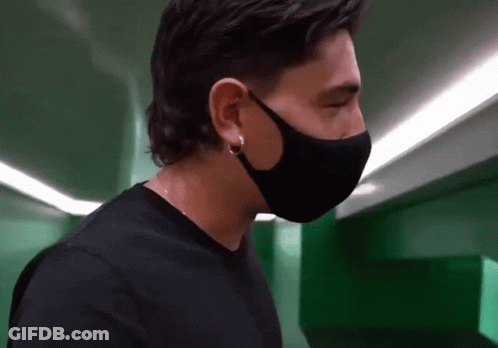 Man In Black Face Mask And Earrings Looking Down GIF