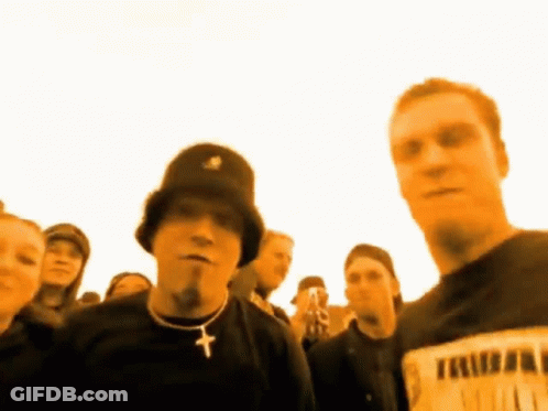 Man In Black Hat And Cross Necklace In Crowd GIF