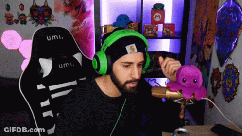 Man In Black Hat And Green Headphones Holding Octopus With Microphone GIF