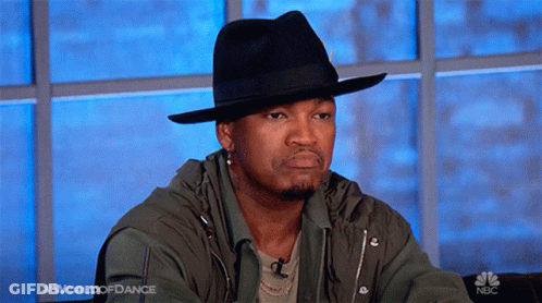 Man In Black Hat And Green Jacket Sitting At Window Saying World Of Dance GIF