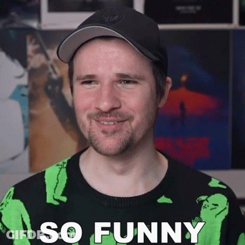 Man In Black Hat And Green Sweater Saying So Funny GIF
