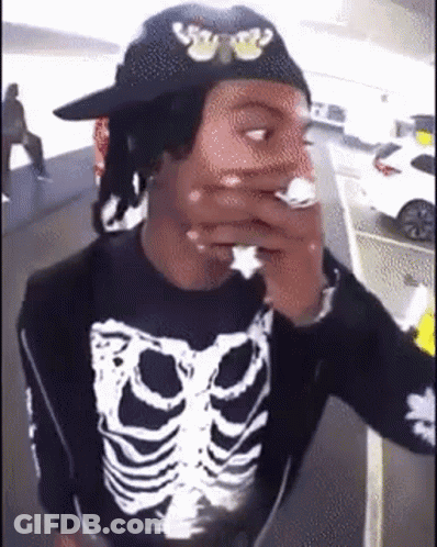 Man In Black Hat And Skeleton Shirt Smoking Cigarette GIF