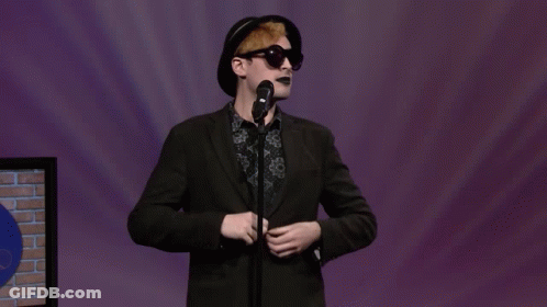 Man In Black Hat And Sunglasses Singing Into Microphone GIF