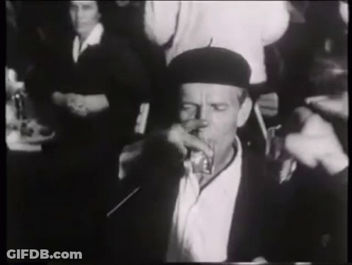 Man In Black Hat Drinking At Table GIF