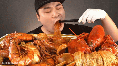 Man In Black Hat Eating Seafood GIF