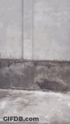 Man In Black Hat Standing By Building GIF