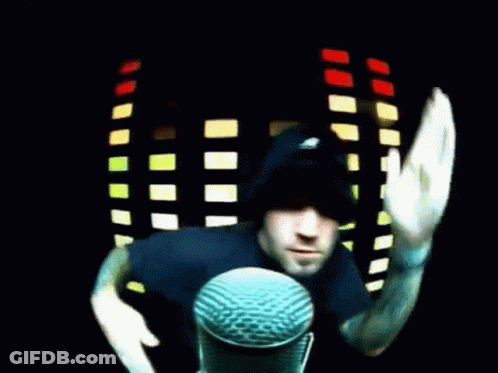 Man In Black Hat Waving At Microphone GIF