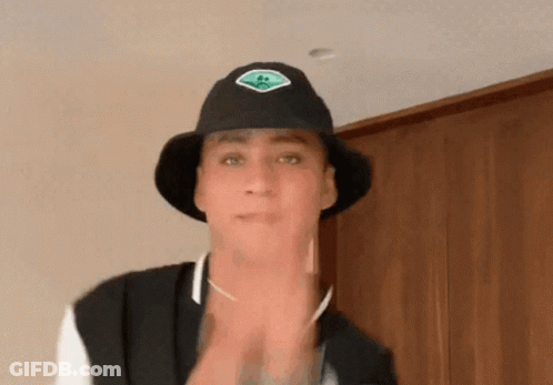 Man In Black Hat With Green Sticker GIF