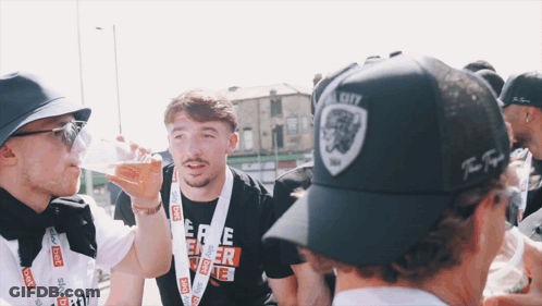 Man In Black Hat With Lion Drinking From Bottle GIF