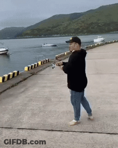 Man In Black Hoodie And Yellow Hat Fishing GIF