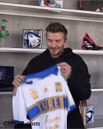 Man In Black Hoodie Holding White And Blue Tigres Jersey GIF