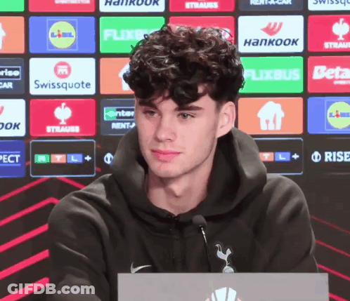 Man In Black Hoodie In Front Of Logo Wall GIF