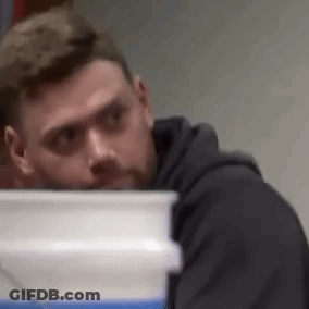 Man In Black Hoodie Looking Behind White Bucket GIF