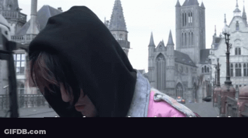 Man In Black Hoodie Standing In Front Of Castle GIF