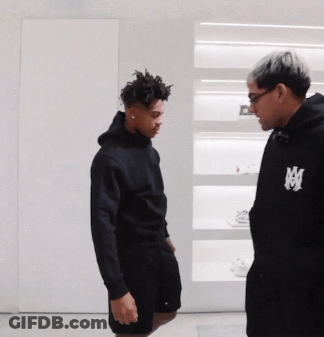 Man In Black Hoodie With Letter M Talks To Another Man GIF