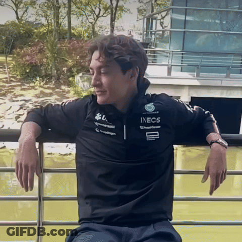 Man In Black Ineos Shirt Leaning On Railing GIF