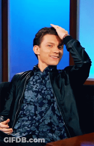 Man In Black Jacket And Floral Shirt Sitting On Couch GIF
