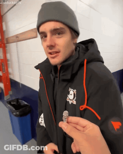 Man In Black Jacket And Grey Beanie Holding Microphone GIF