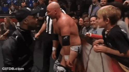 Man In Black Jacket Beside Wrestler In Ring GIF