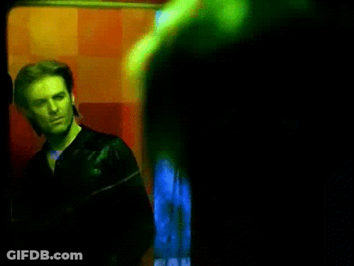 Man In Black Jacket By Red Wall GIF