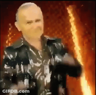 Man In Black Jacket Holding Torch In Front Of Fire GIF