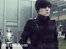 Man In Black Jacket In Front Of Building With Others GIF