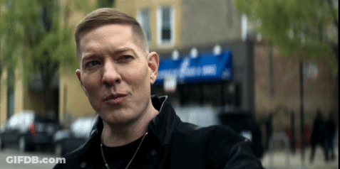 Man In Black Jacket In Front Of Domino Building GIF