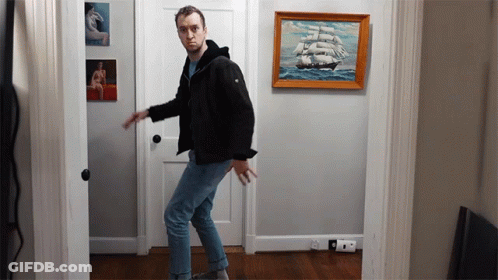 Man In Black Jacket In Front Of Sailboat GIF