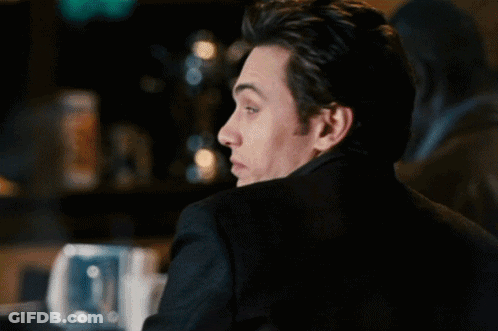Man In Black Jacket Looking Over Shoulder GIF