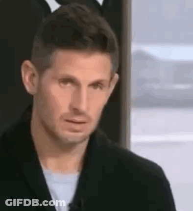 Man In Black Jacket Making Funny Face By Window GIF