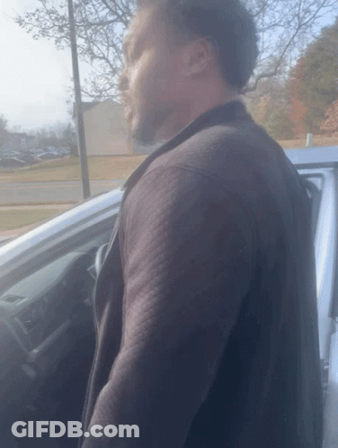 Man In Black Jacket Next To Silver Car GIF