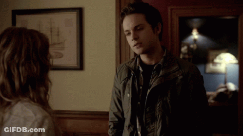 Man In Black Jacket Next To Woman In Room GIF