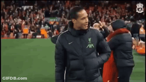 Man In Black Jacket On Soccer Field With Crowd GIF