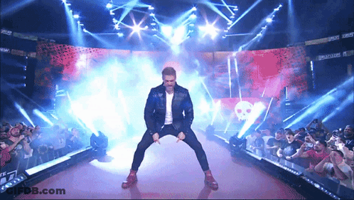 Man In Black Jacket On Stage With TNA Sign GIF