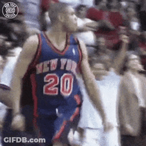 Man In Black Jacket Sitting By Bookshelf GIF