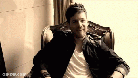 Man In Black Jacket Sitting In Chair GIF