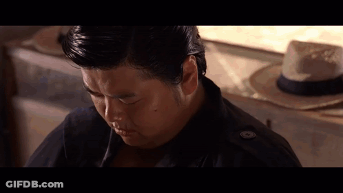 Man In Black Jacket Sitting In Front Of Straw Hat GIF