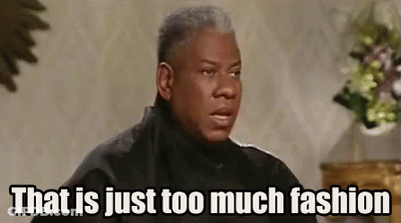 Man In Black Jacket Sitting In Front Of Vase Of Flowers GIF